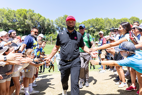 manos extendidas hacia el golfista mientras pasa por la línea